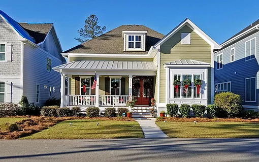 a beige house with plants in the front yard