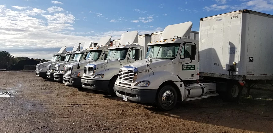 a row of white trucks from Commercial Pine Straw